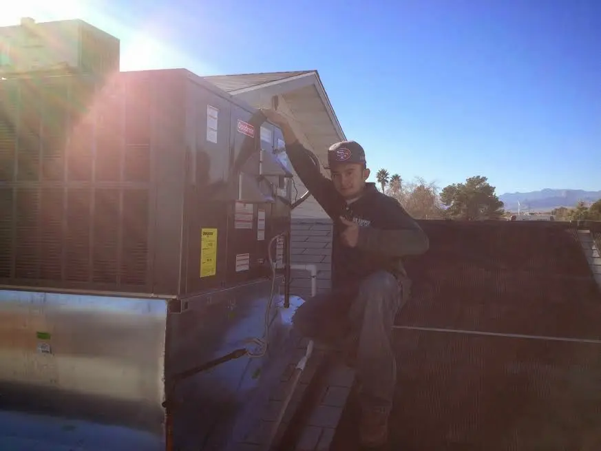 HVAC technician performing Boiler Repair on a rooftop unit in Evergreen